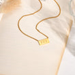 Load image into Gallery viewer, 777 angel number pendant gold necklace laid out